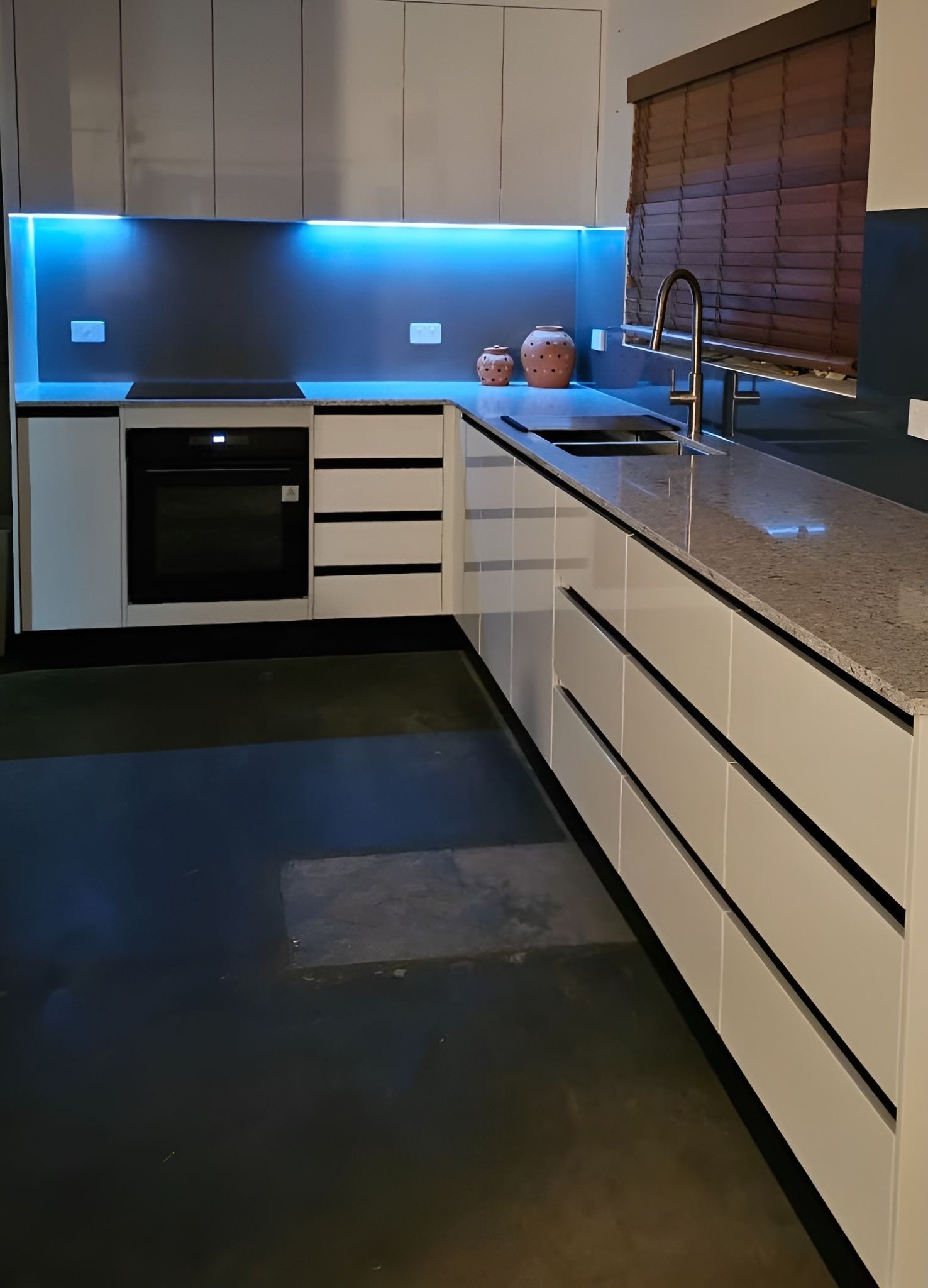 A Kitchen With White Cabinets and a Stove Top Oven — Mackay Cabinetmaking Service In Glenella, QLD