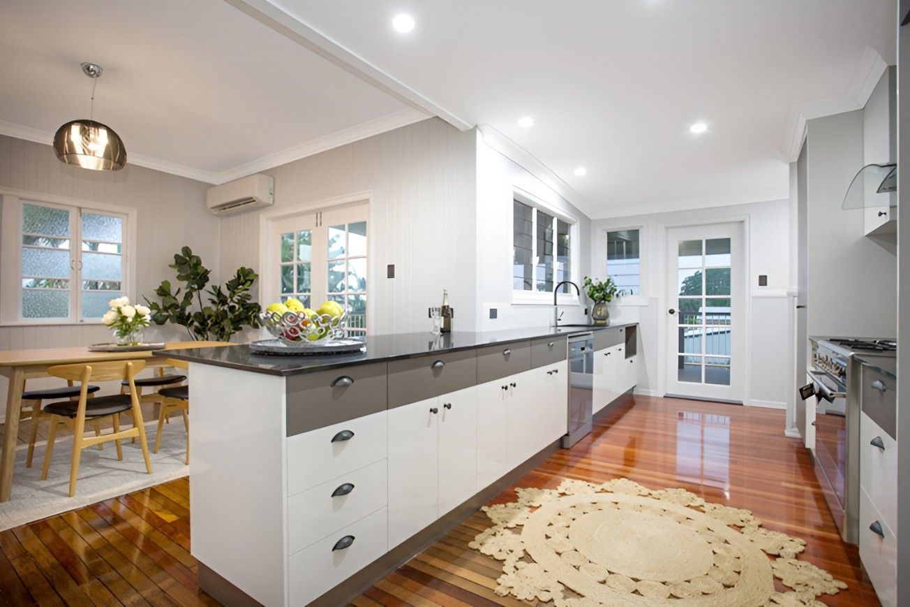 A Kitchen With a Large Island in the Middle and a Rug on the Floor — Mackay Cabinetmaking Service In Glenella, QLD