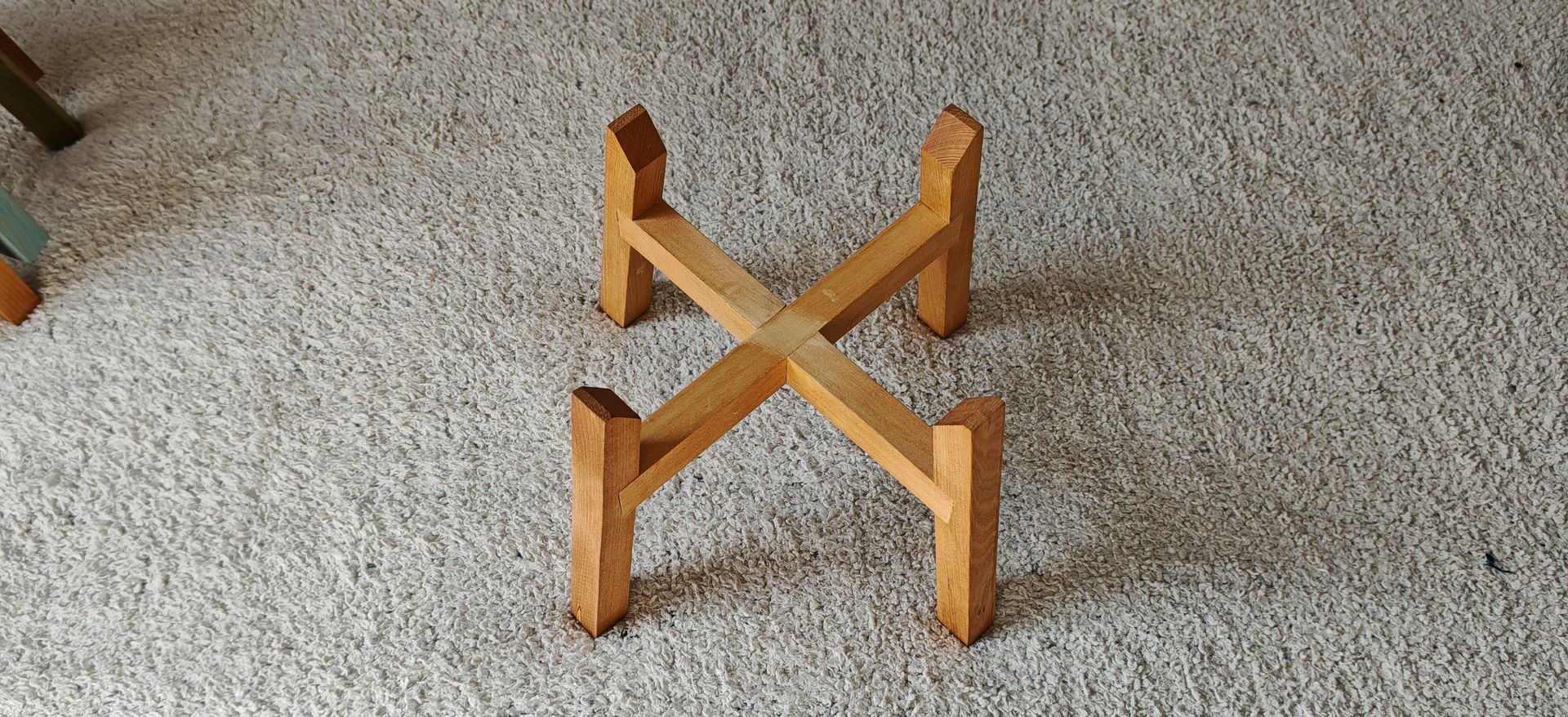 Un recipiente de acero inoxidable está sobre un soporte de madera sobre una alfombra.