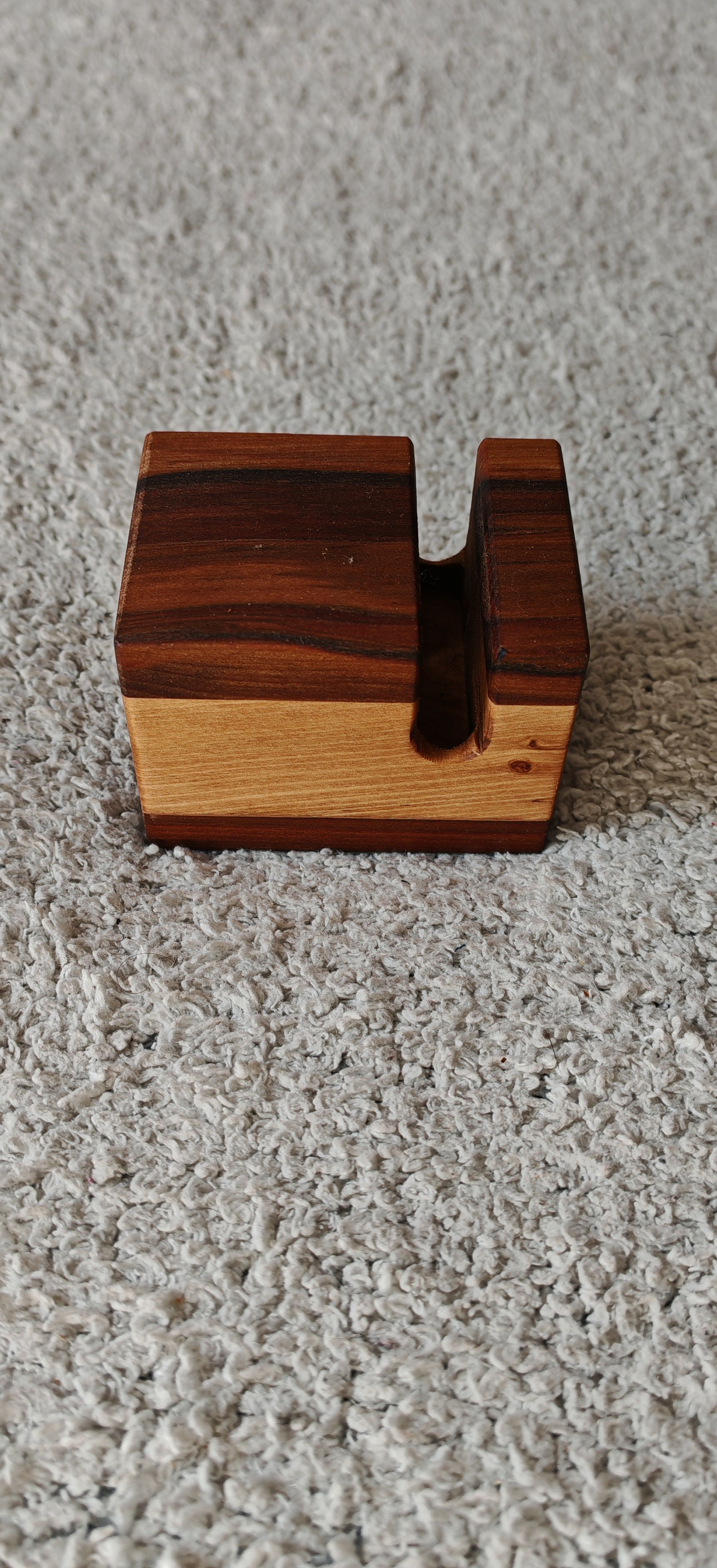 Una pequeña caja de madera está sobre una alfombra.