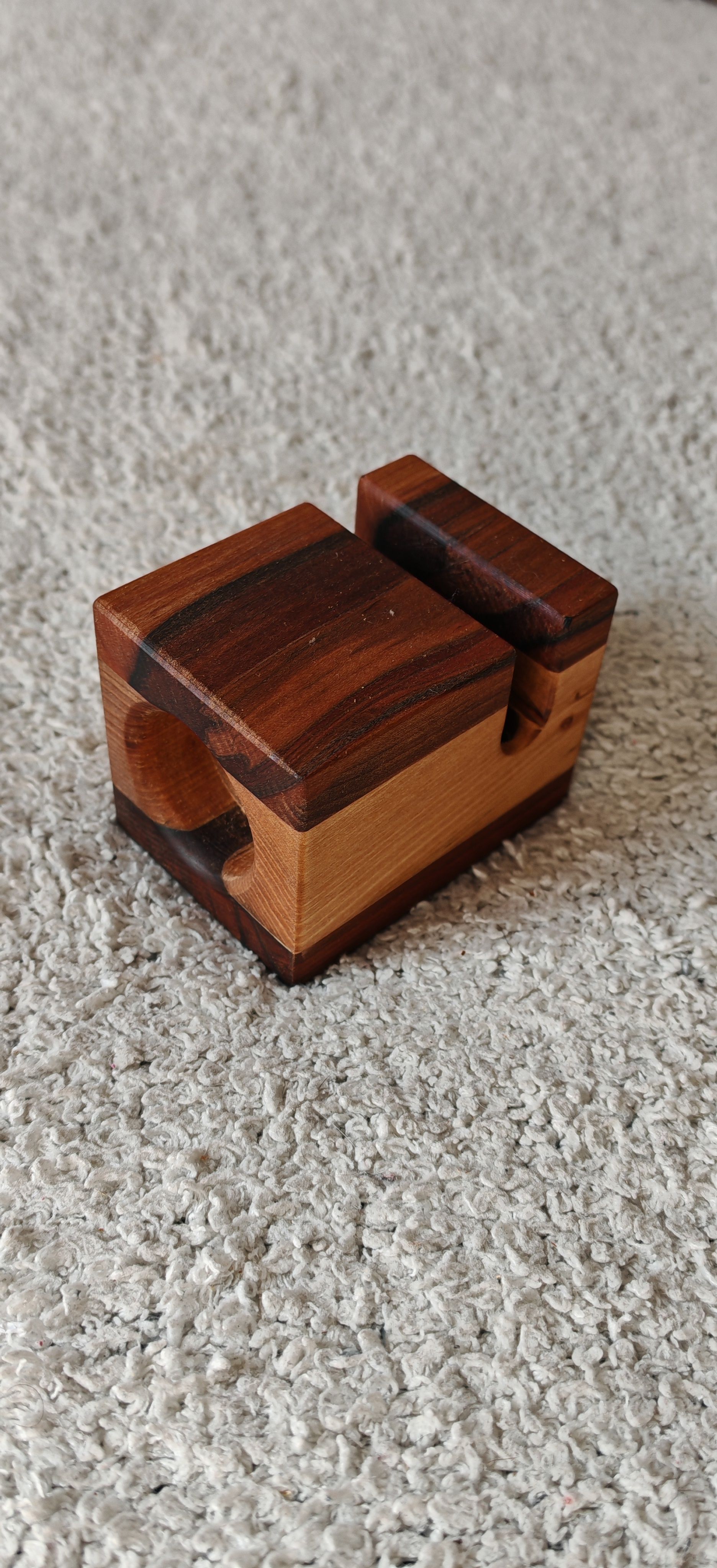 Una pequeña caja de madera está sobre una alfombra.