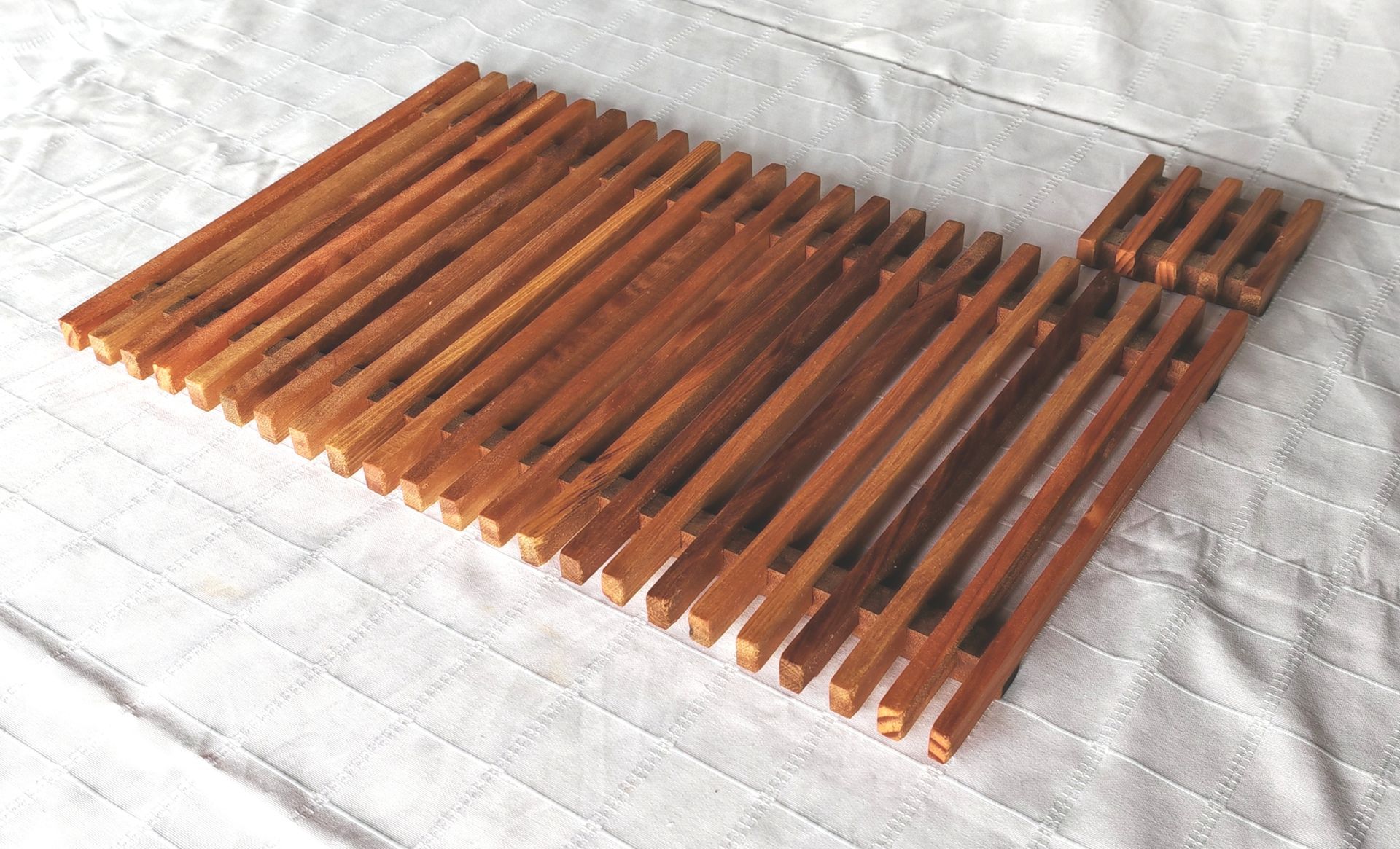 Un peine de madera reposa encima de una manta blanca.