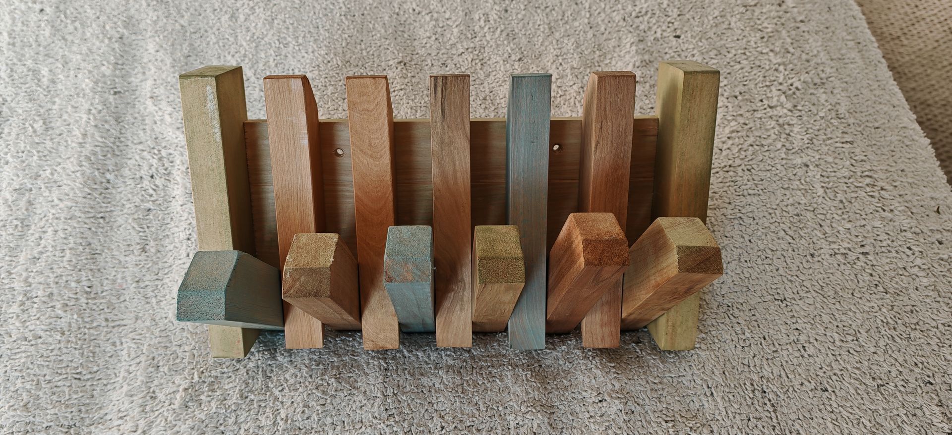 Un xilófono de madera está encima de una cama.