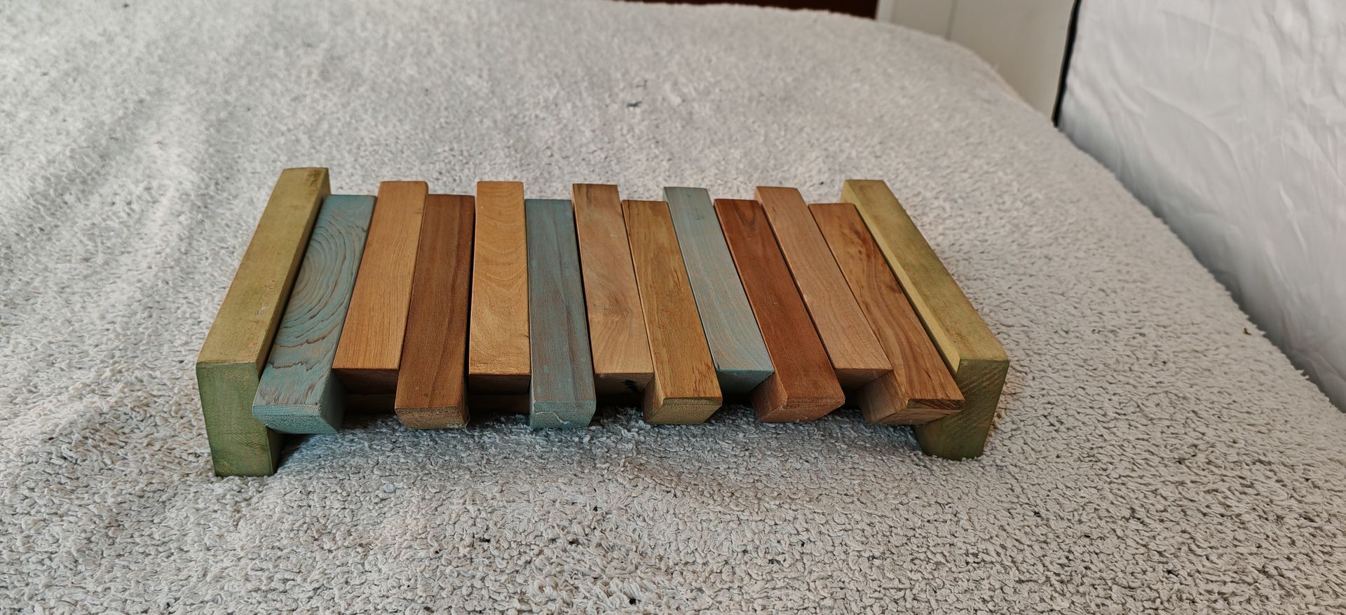 Un xilófono de madera está encima de una cama.