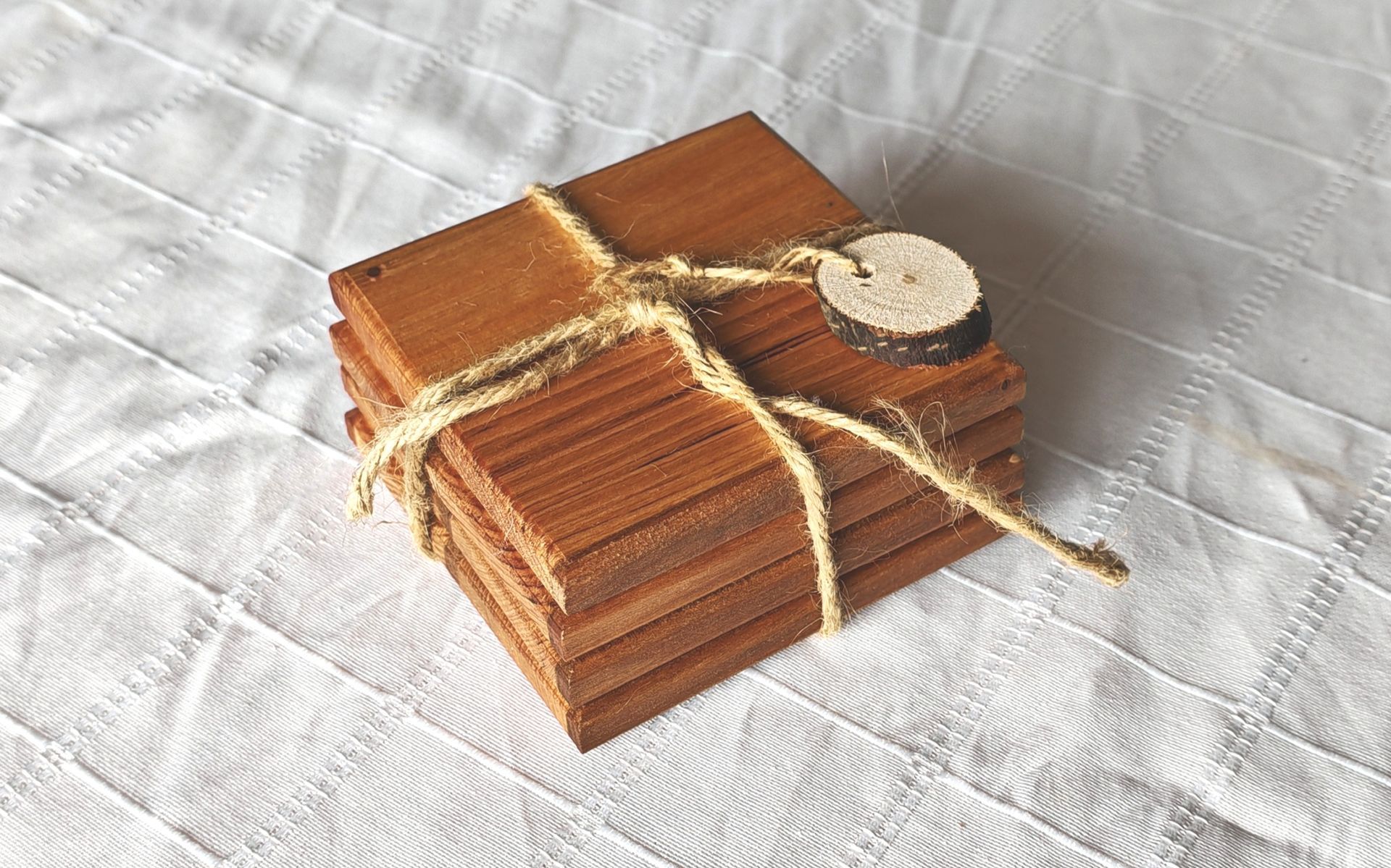 Una pila de posavasos de madera están sobre una mesa de madera.