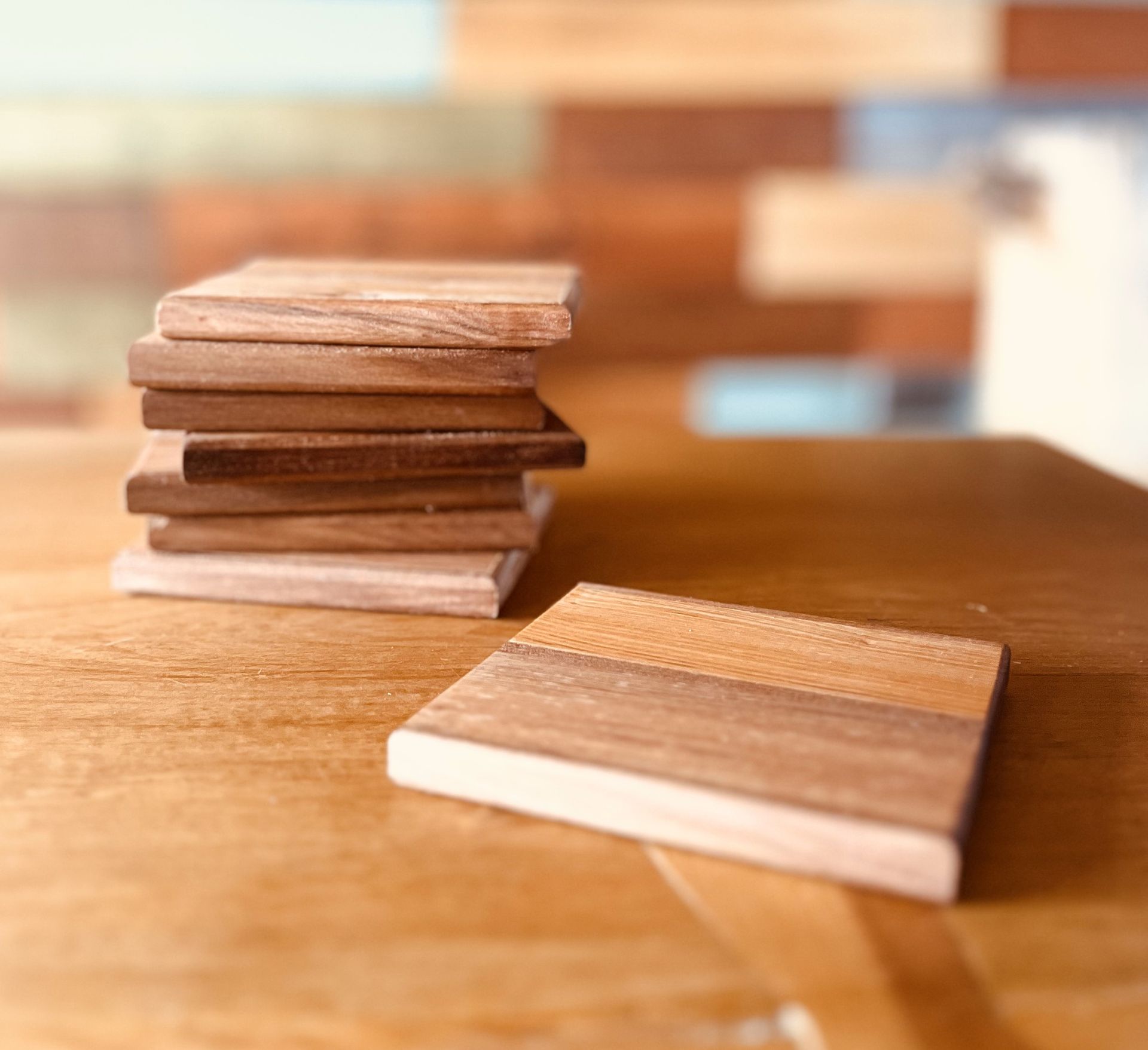 Una pila de posavasos de madera están sobre una mesa de madera.