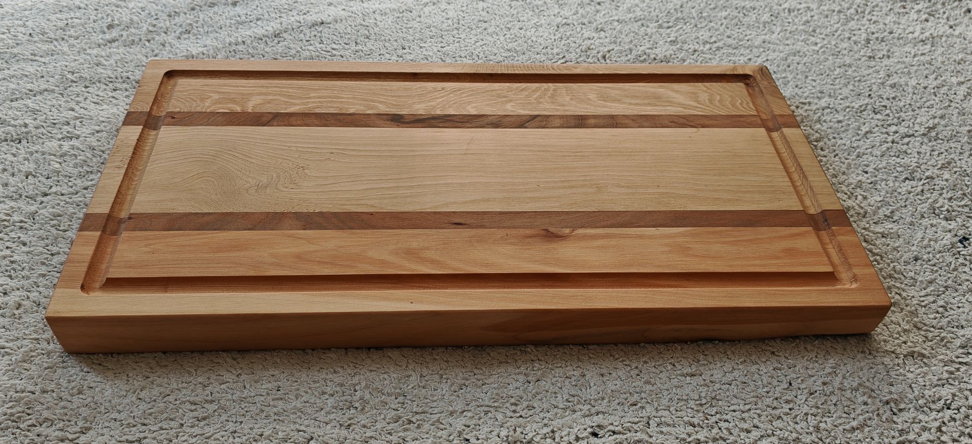 Una tabla de cortar de madera está encima de una cama.