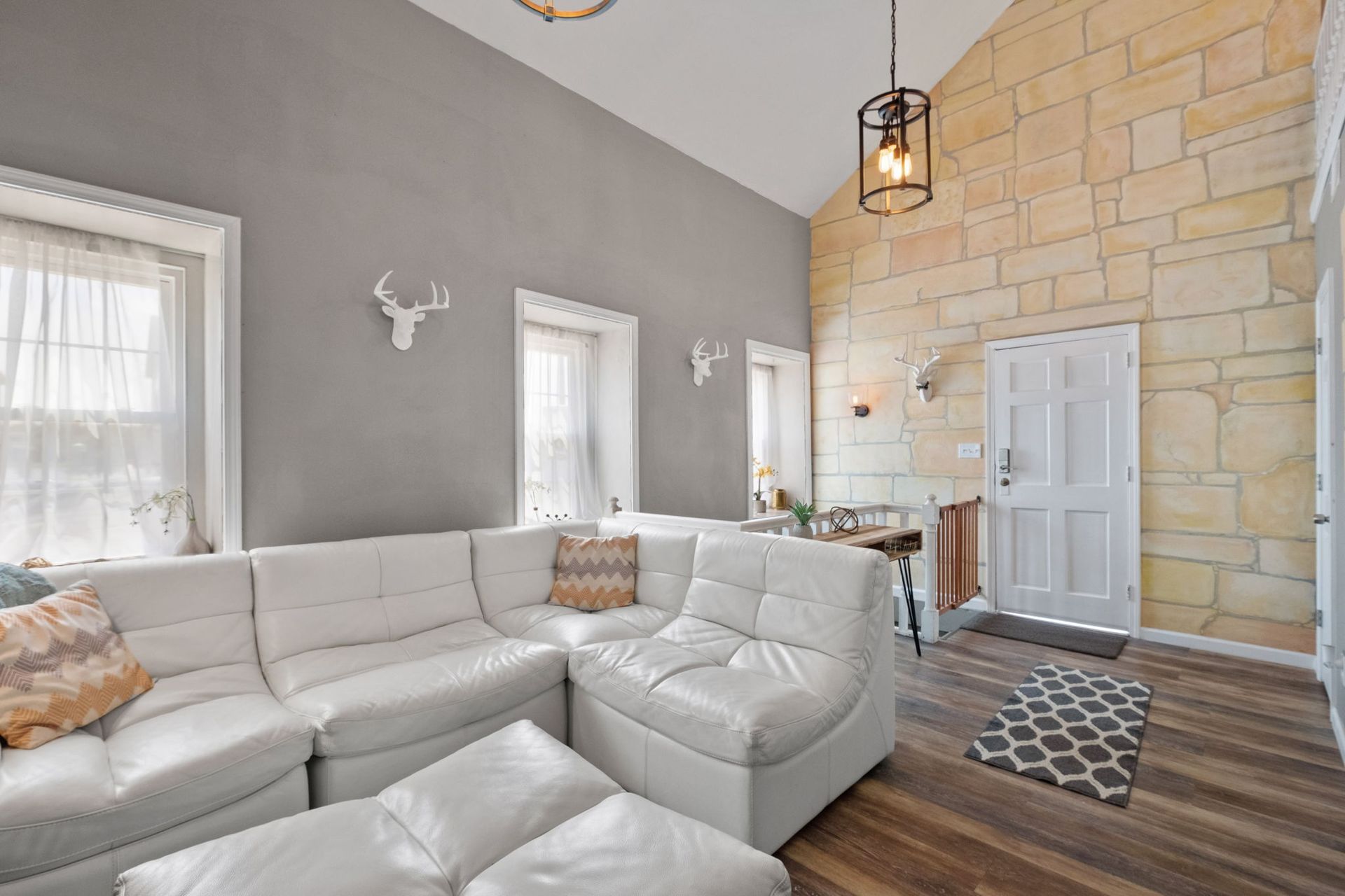 A living room with a couch , chair , and ottoman.