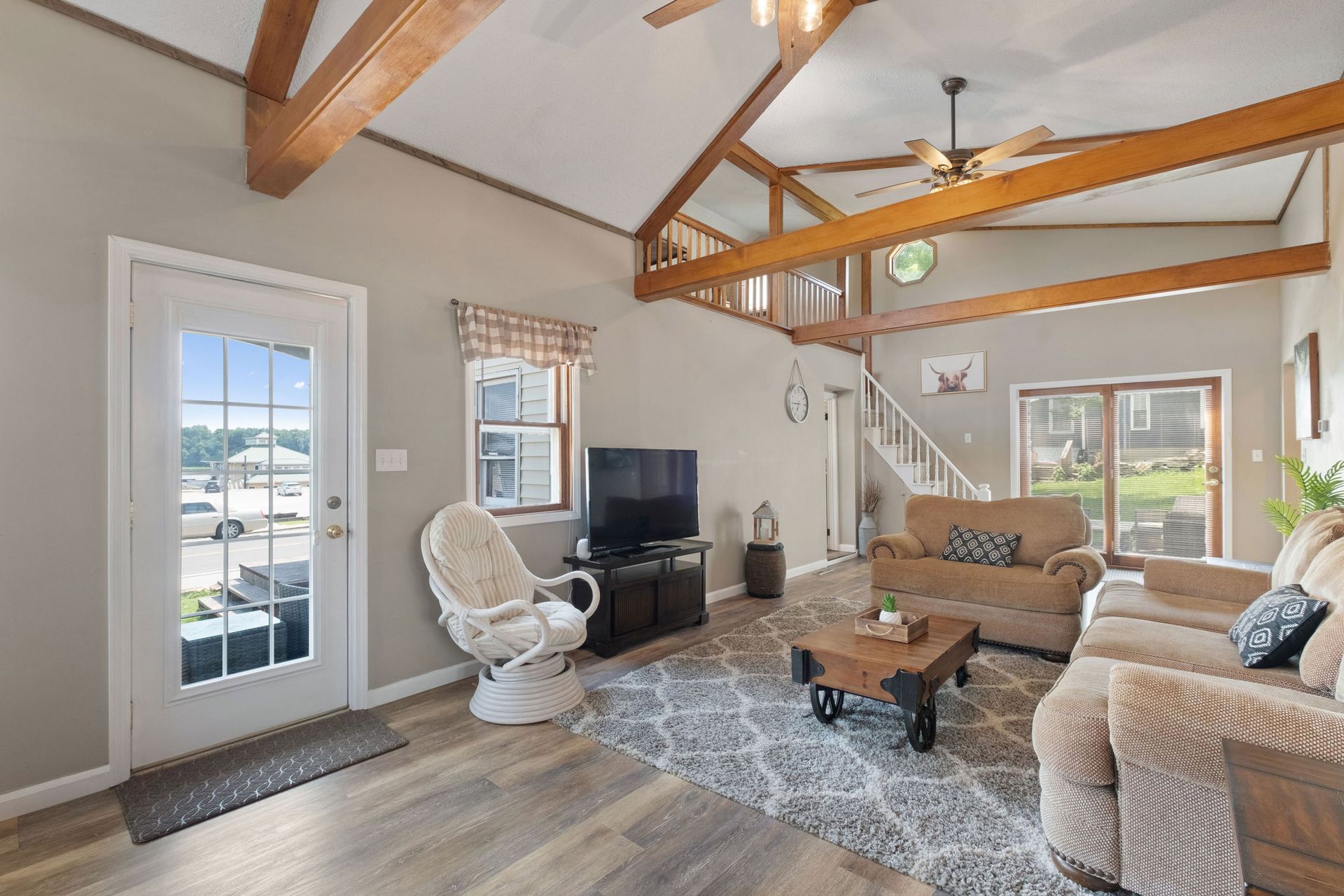 A living room with a couch , chair , table and television.