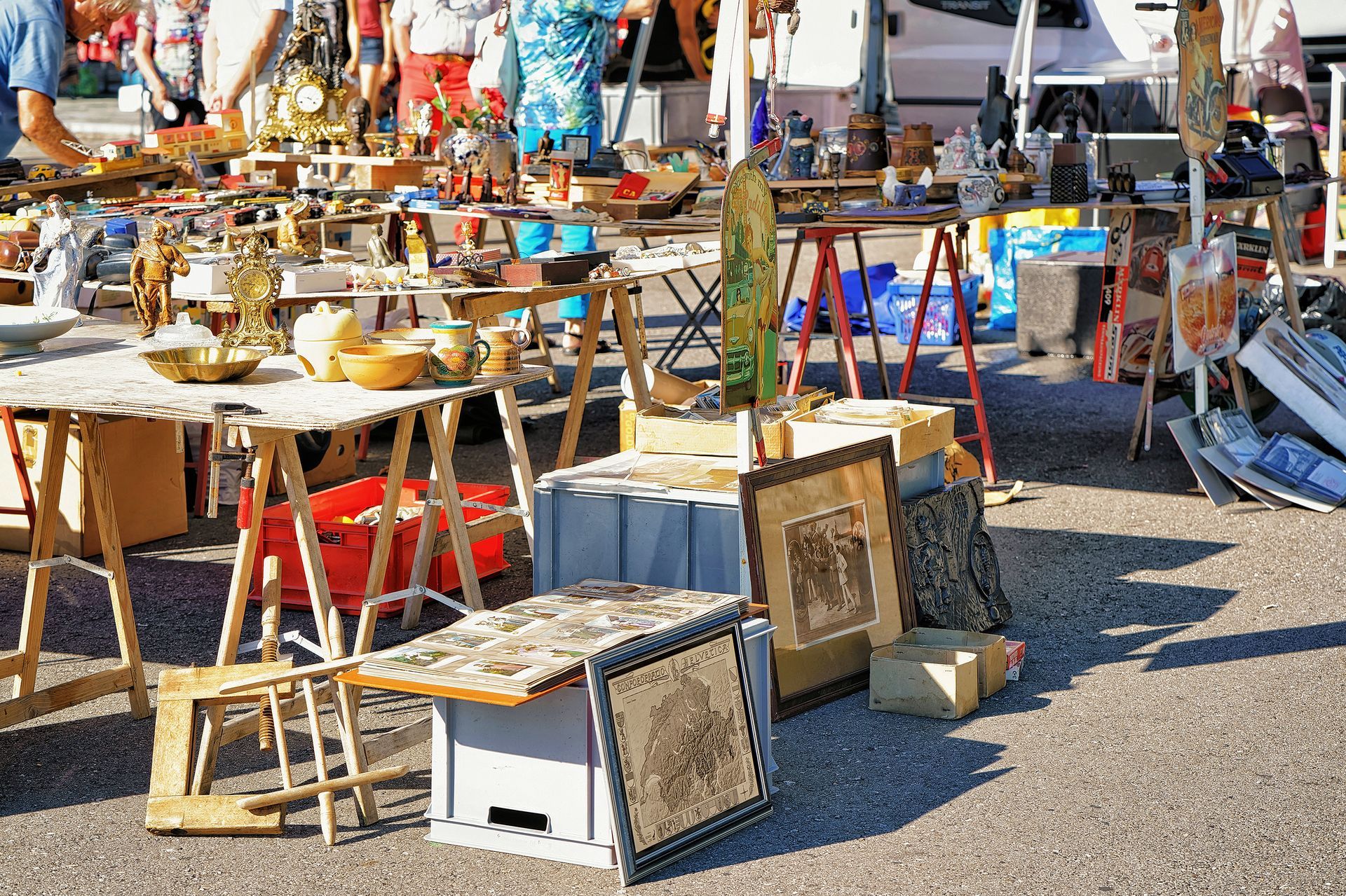 A flea market with lots of tables and boxes on the ground.