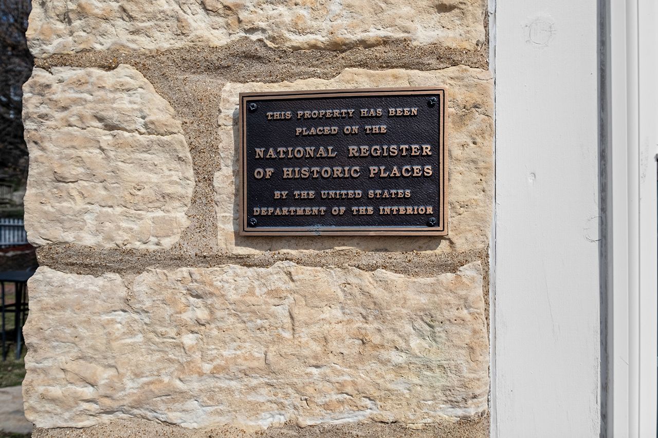 A plaque on a stone wall that says `` national register of historic places ''.