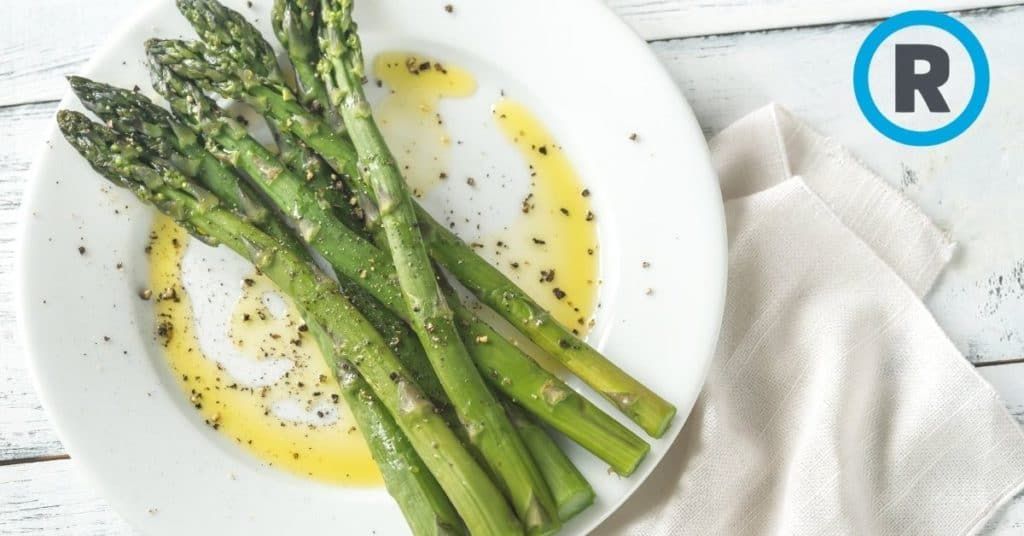 A white plate topped with asparagus and a napkin on a table.