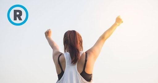 A woman is standing with her arms in the air.