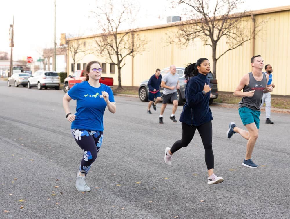 A group of people are running down a street.