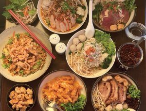 A table topped with bowls of food and chopsticks.