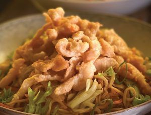 A close up of a bowl of food with shrimp and noodles.