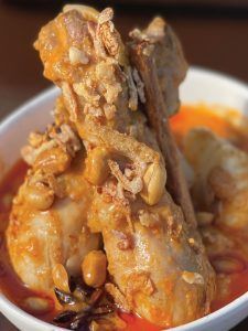 A close up of a bowl of chicken stew on a table.