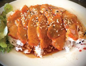 A plate of food with meat and rice on a table.