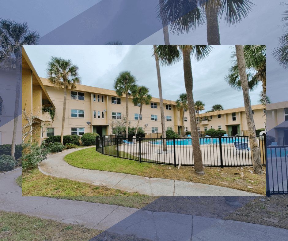Apartment complex with a pool, palm trees, and a walkway.