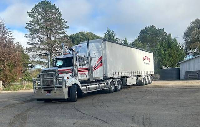 a large white semi truck is parked in a parking lot.