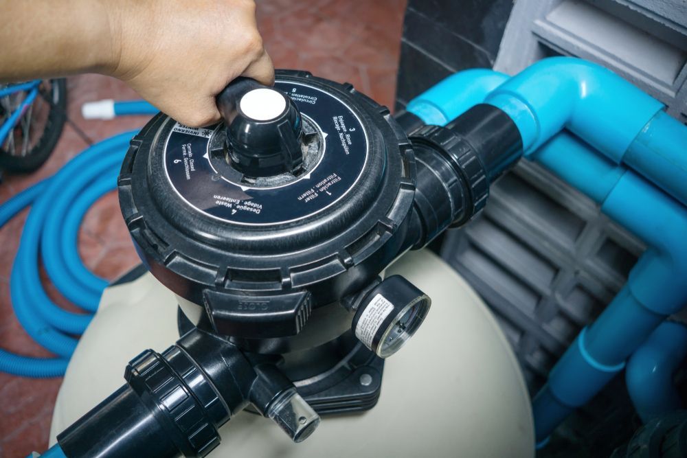 Hand Turning a Black Multiport Valve on a Pool Filter — Port Douglas Pool Shop in Craiglie, QLD