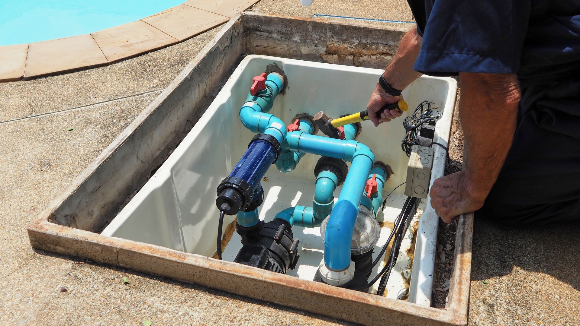 Person Adjusting Pool Equipment Inside an Open, Rectangular Box — Port Douglas Pool Shop in Craiglie, QLD