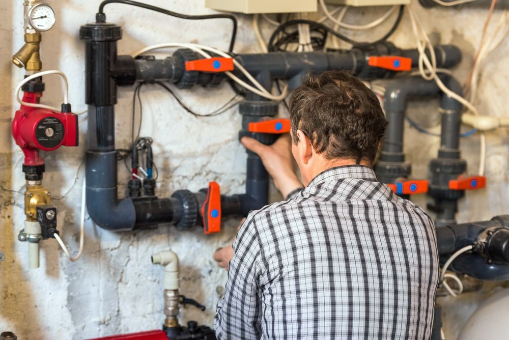 Man in Plaid Shirt Working on Plumbing System — Port Douglas Pool Shop in Daintree, QLD