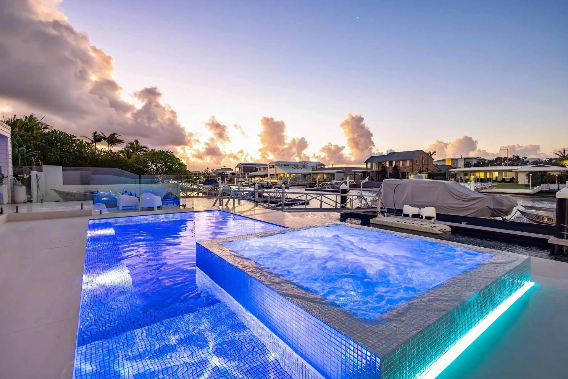 Outdoor Pool and Jacuzzi With Blue Lights, Marina in Background — Port Douglas Pool Shop in Oak Beach, QLD