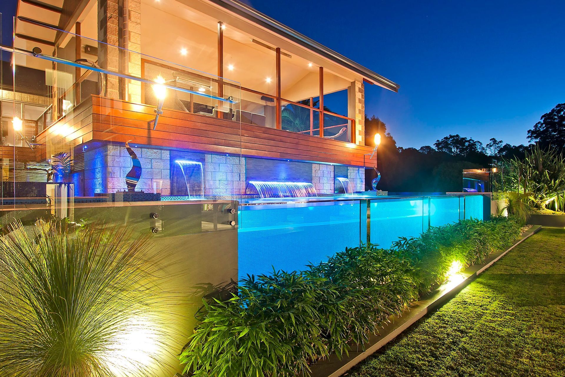 Luxurious Home With an Illuminated, Clear-walled Pool at Night — Port Douglas Pool Shop in Craiglie, QLD