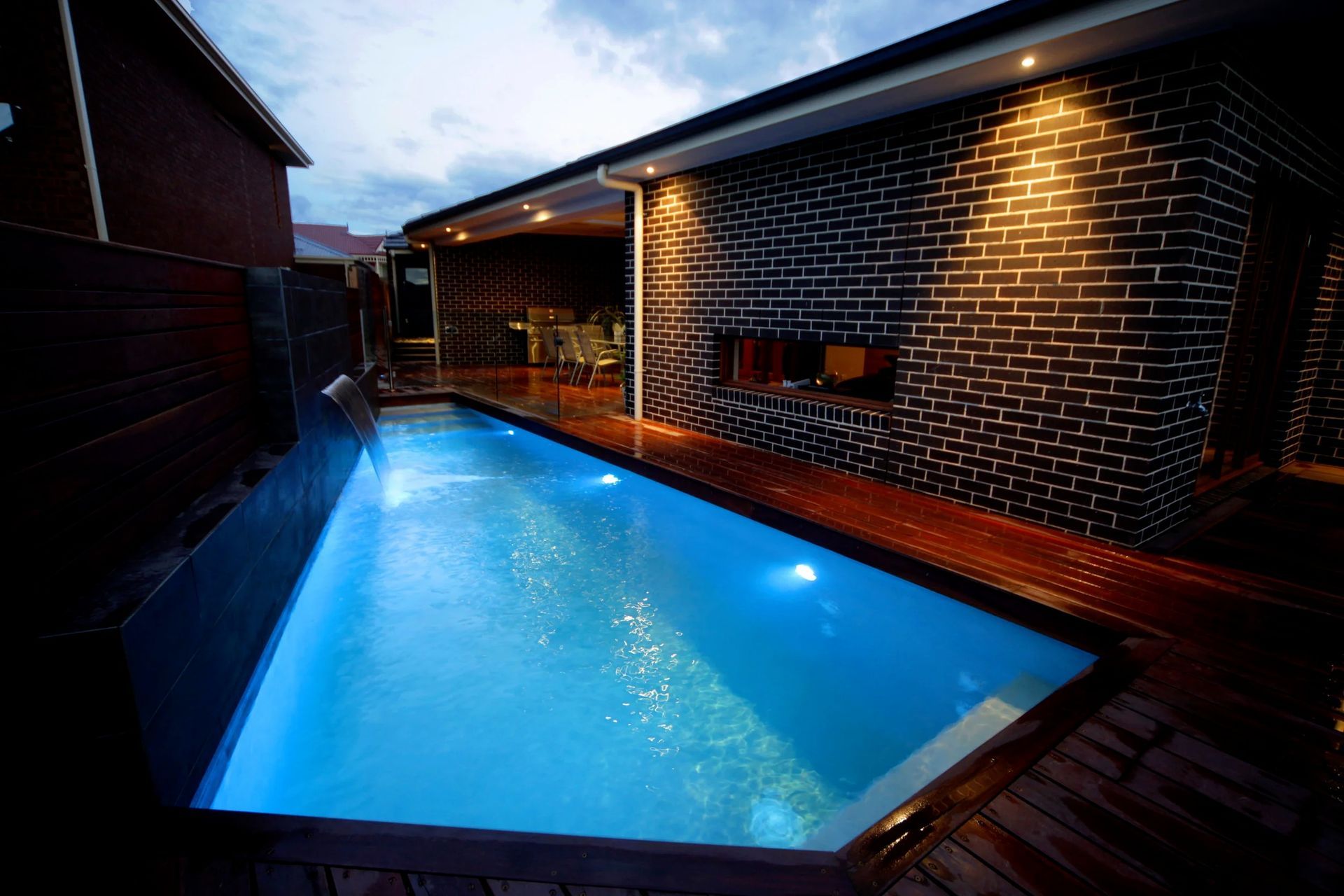 Rectangular Pool With Blue Lights Surrounded by a Wooden Deck — Port Douglas Pool Shop in Craiglie, QLD