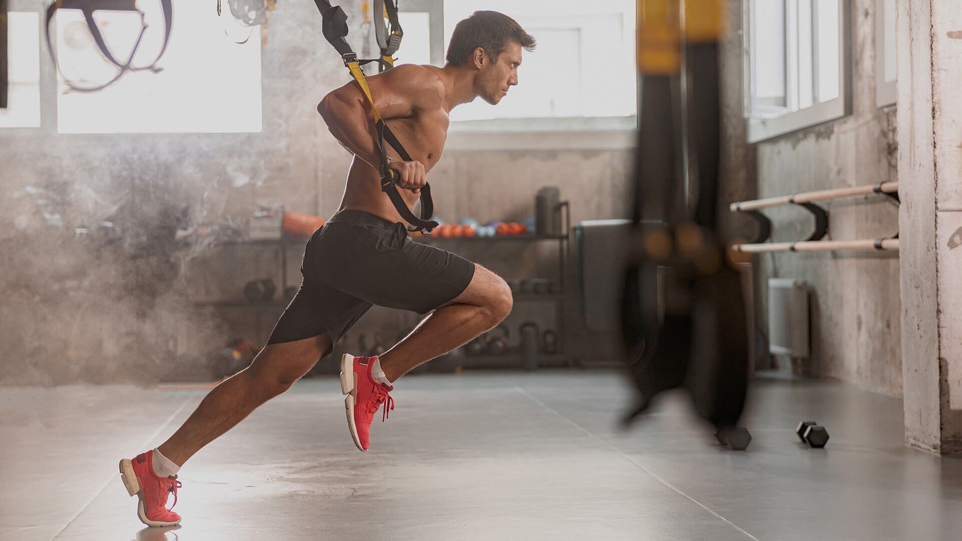 A Shirtless Man Is Doing Trx Exercises In A Gym — Avon Lake, OH — Boost Wellness