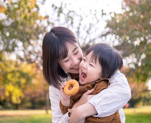 Woman feedling her daughter a doughnut