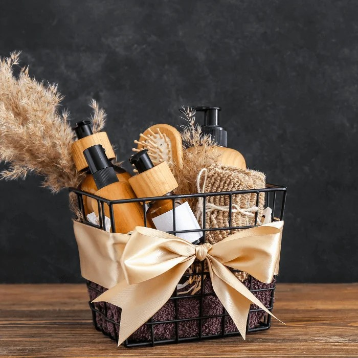 A basket filled with bottles and brushes with a bow on a wooden table.