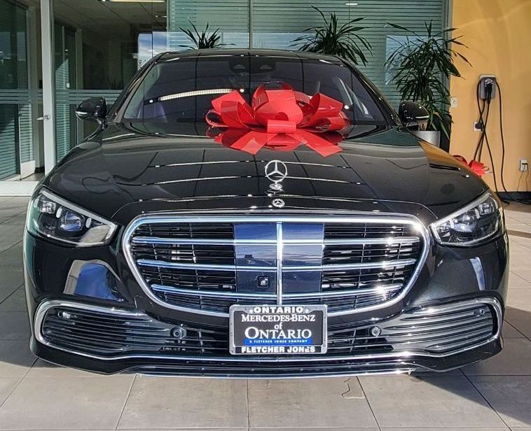 A black mercedes benz s class is parked in a parking lot.