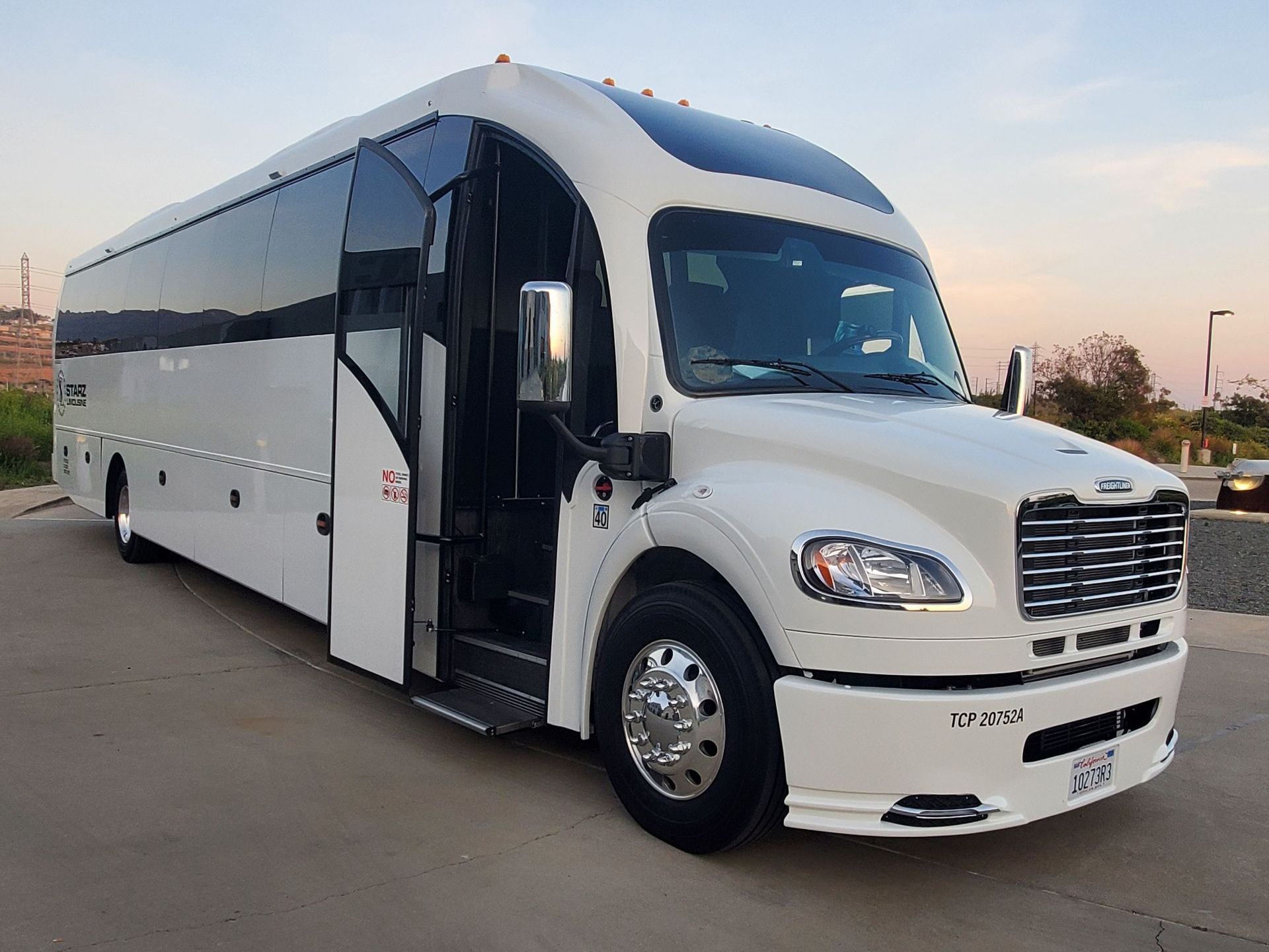 A silver limousine is parked in a parking lot