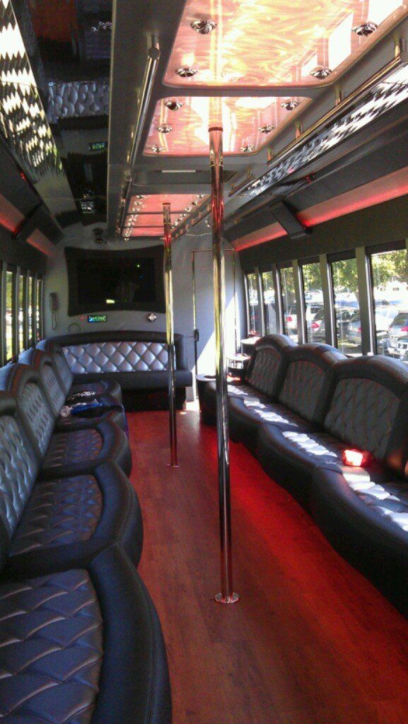 The inside of a bus with a lot of seats and a pole.