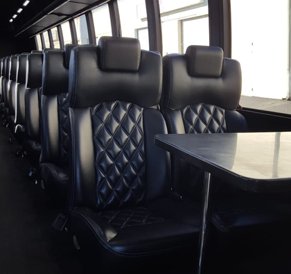 The inside of a bus with black seats and a table