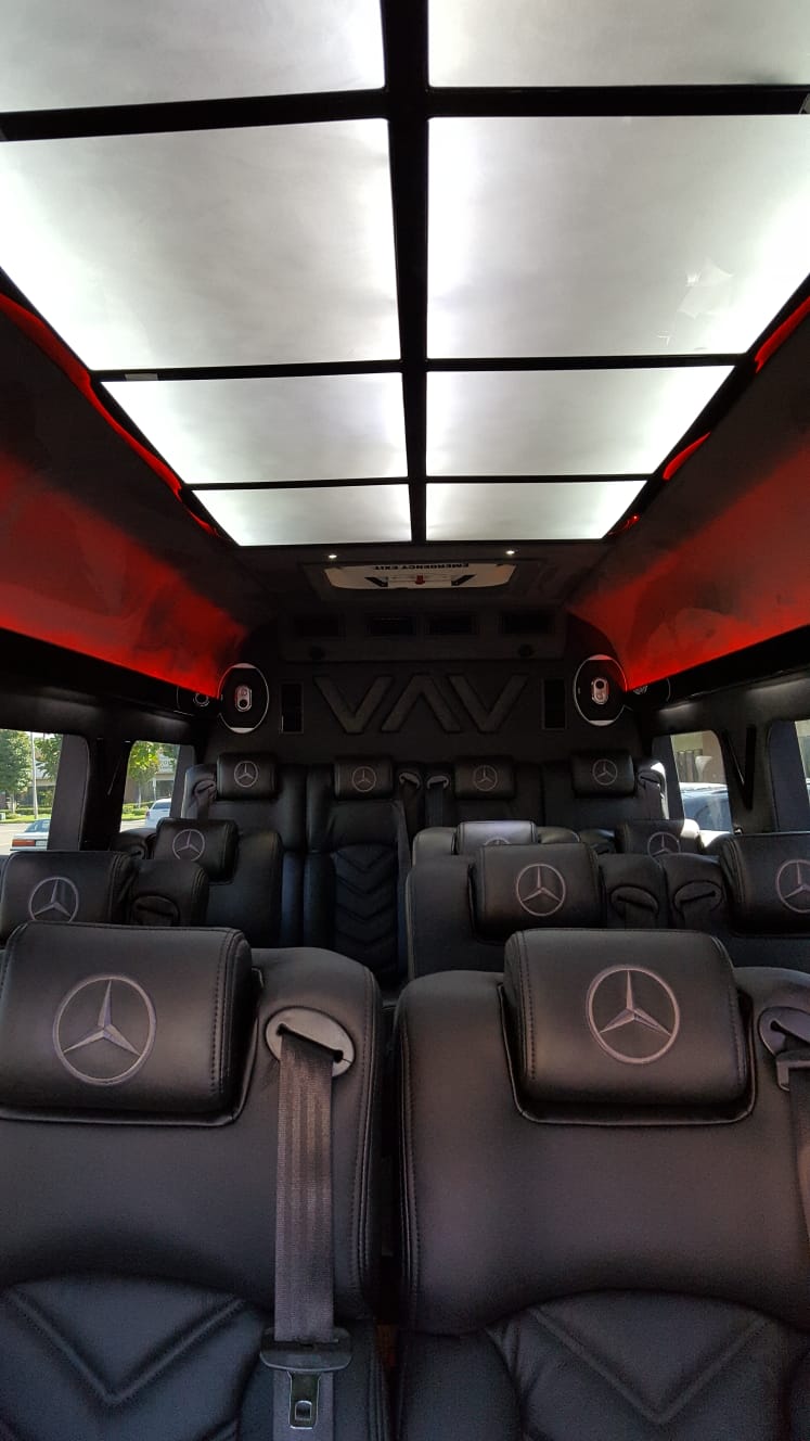 The inside of a mercedes van with a lot of seats and a ceiling light.