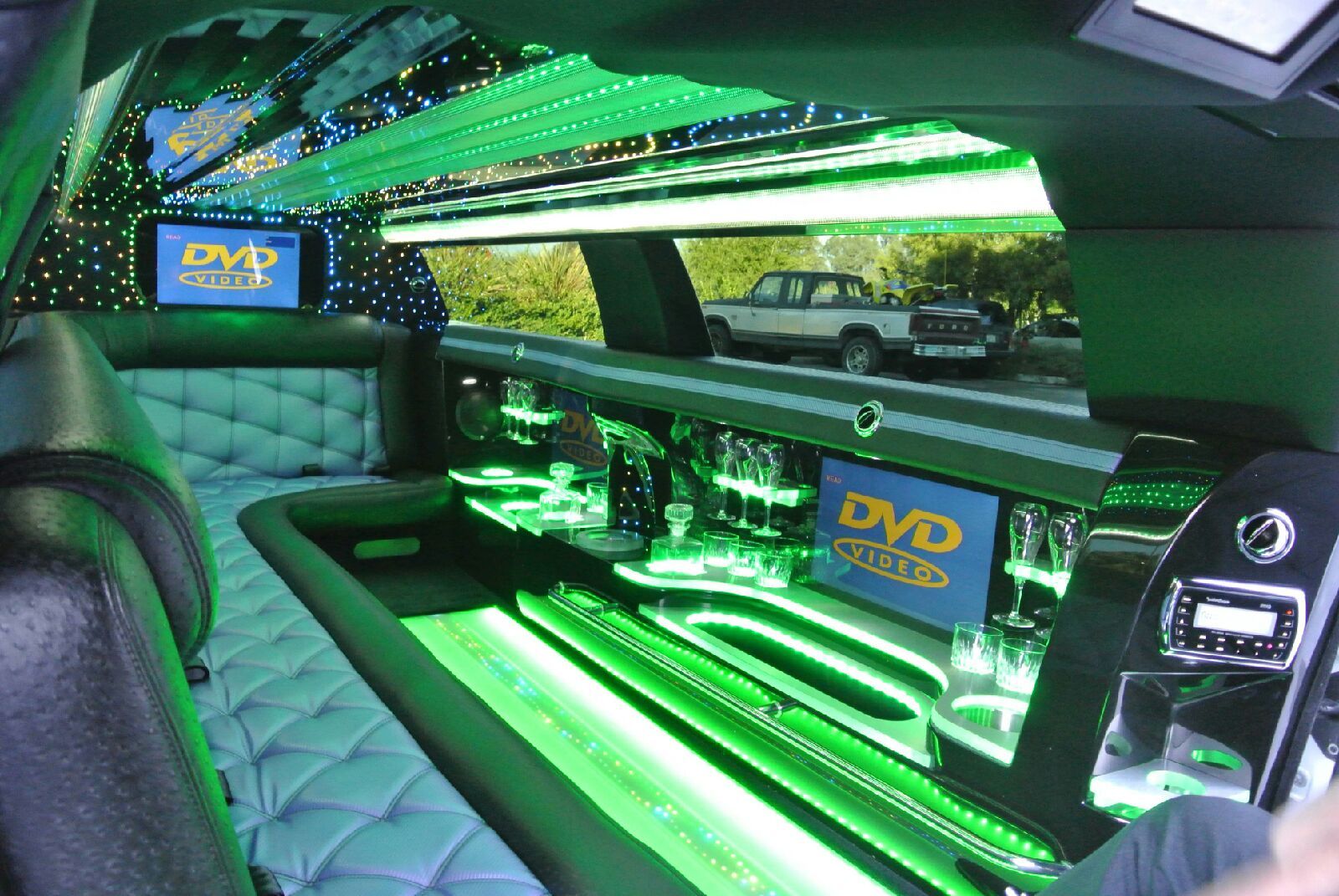 The inside of a green limousine with a dvd player