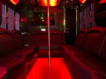 The inside of a limousine with a pole in the middle of the room.