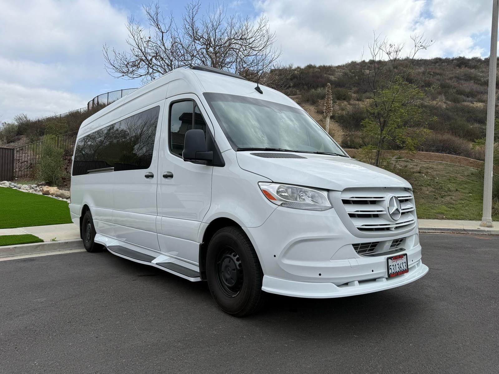 A white van is parked in a parking lot with its doors open.