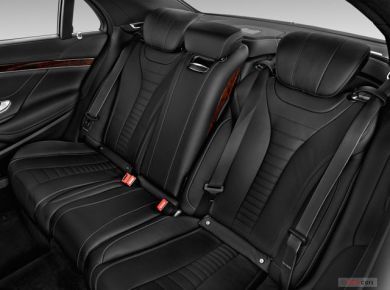 The back seats of a mercedes benz s class are black leather and have seat belts.