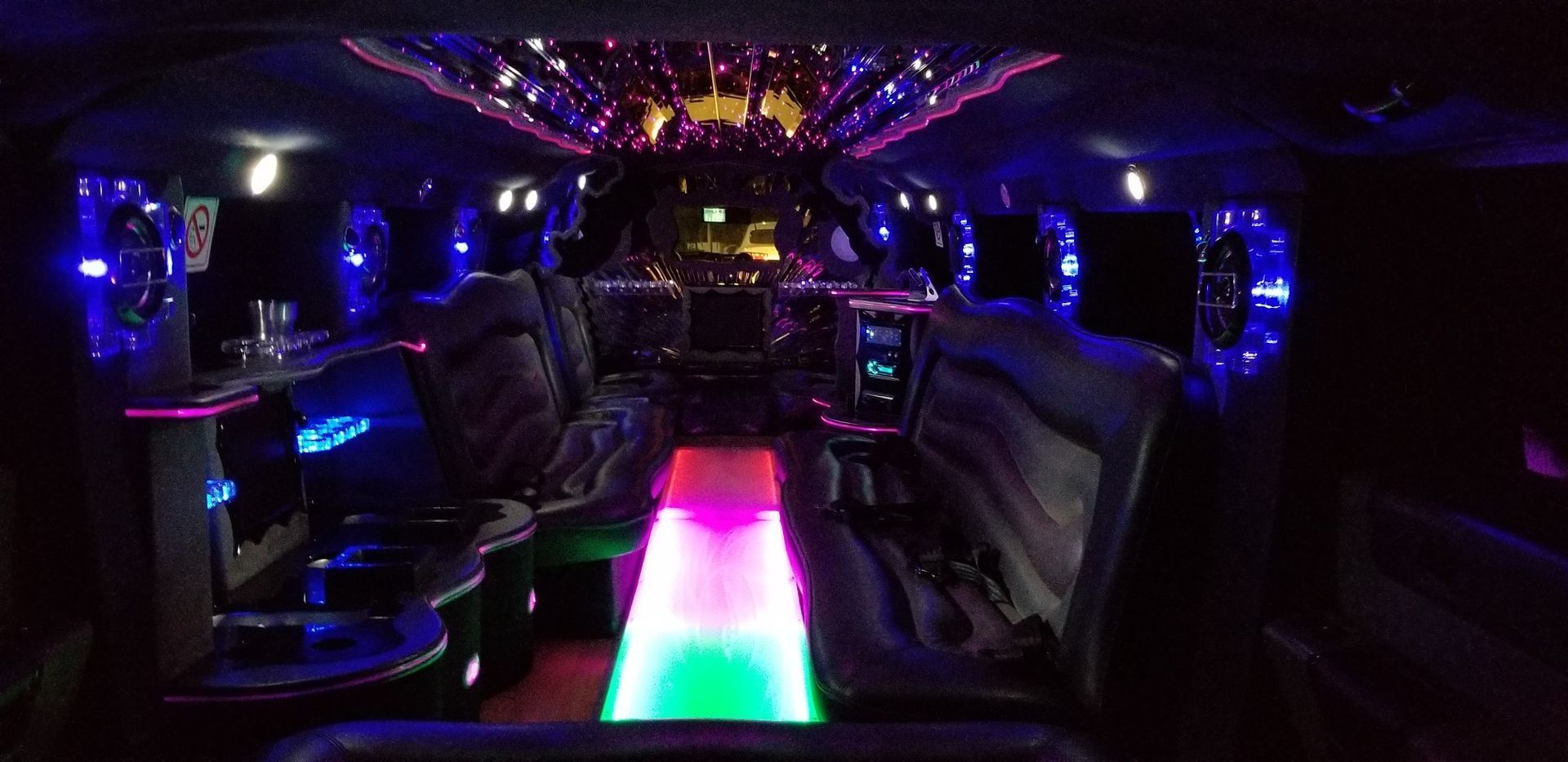 The inside of a limousine with colorful lights on the ceiling.