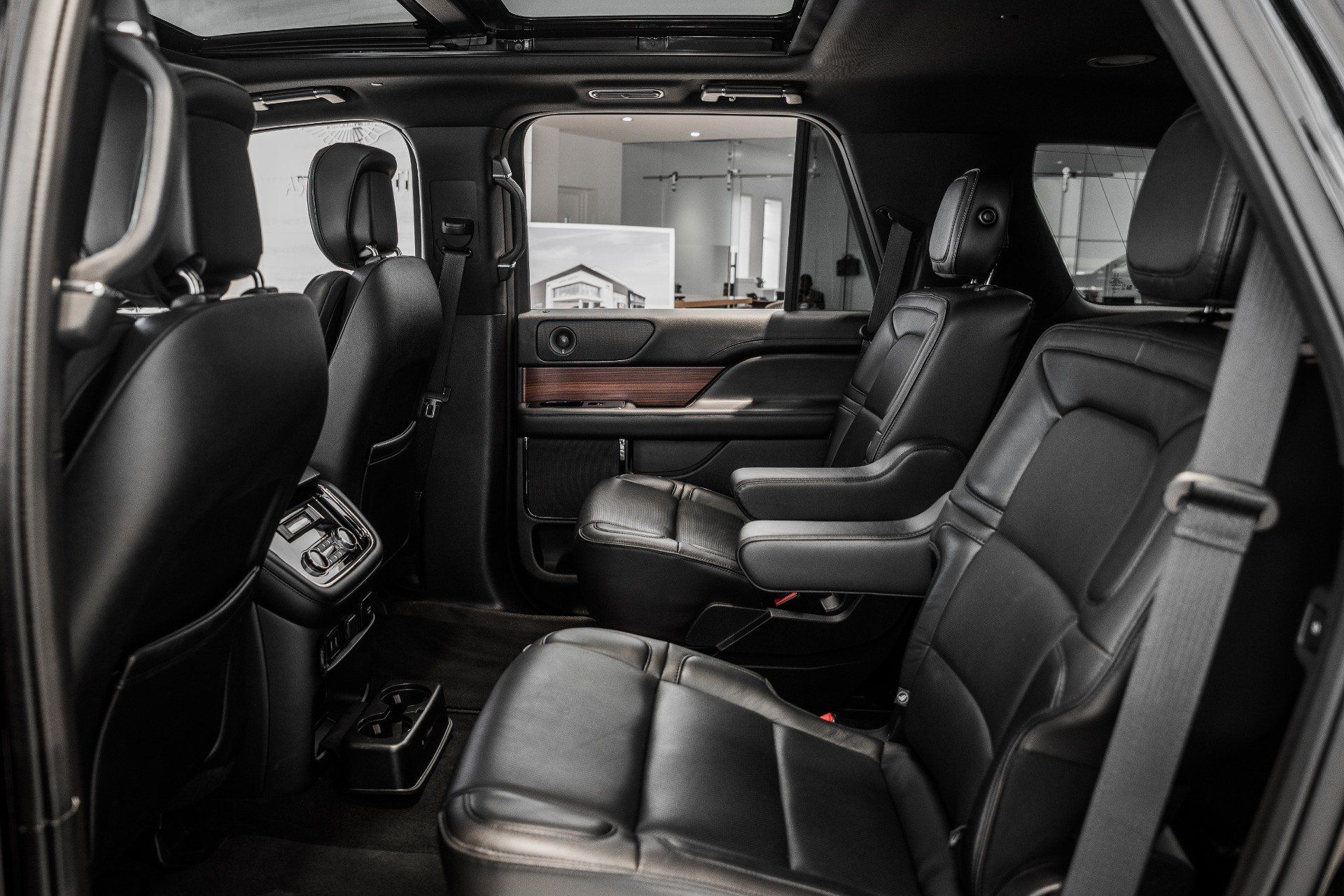 The back seat of a black ford navigator with a sunroof.