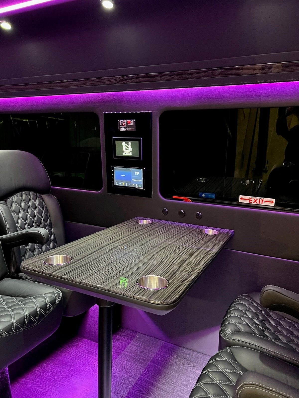 There is a table in the back of a van with purple lights.