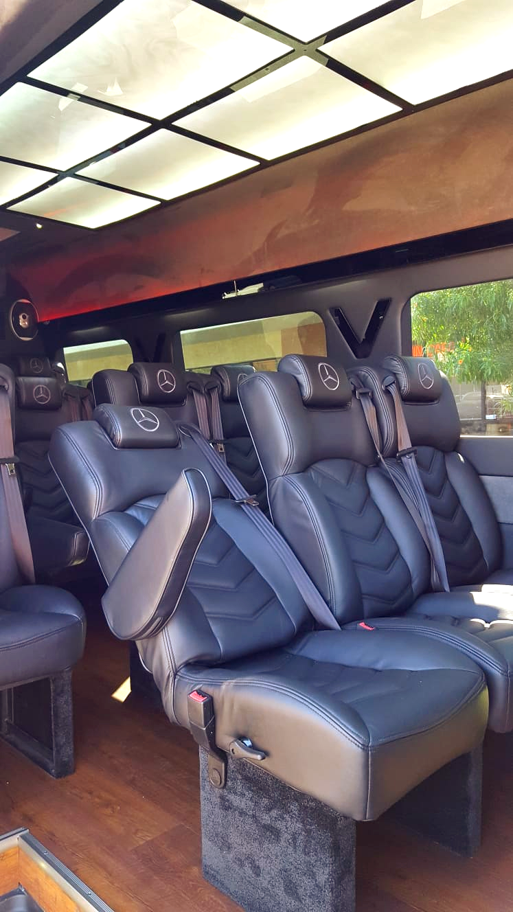 A row of black leather seats in a van.