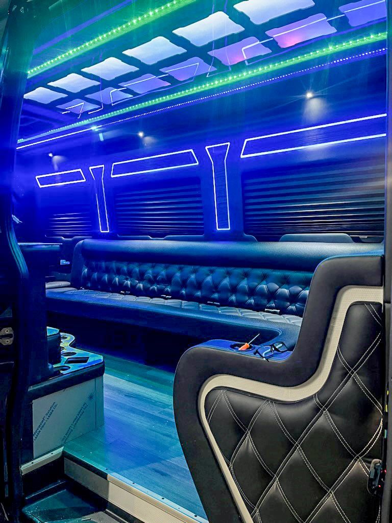 The inside of a bus with a couch and a chair.