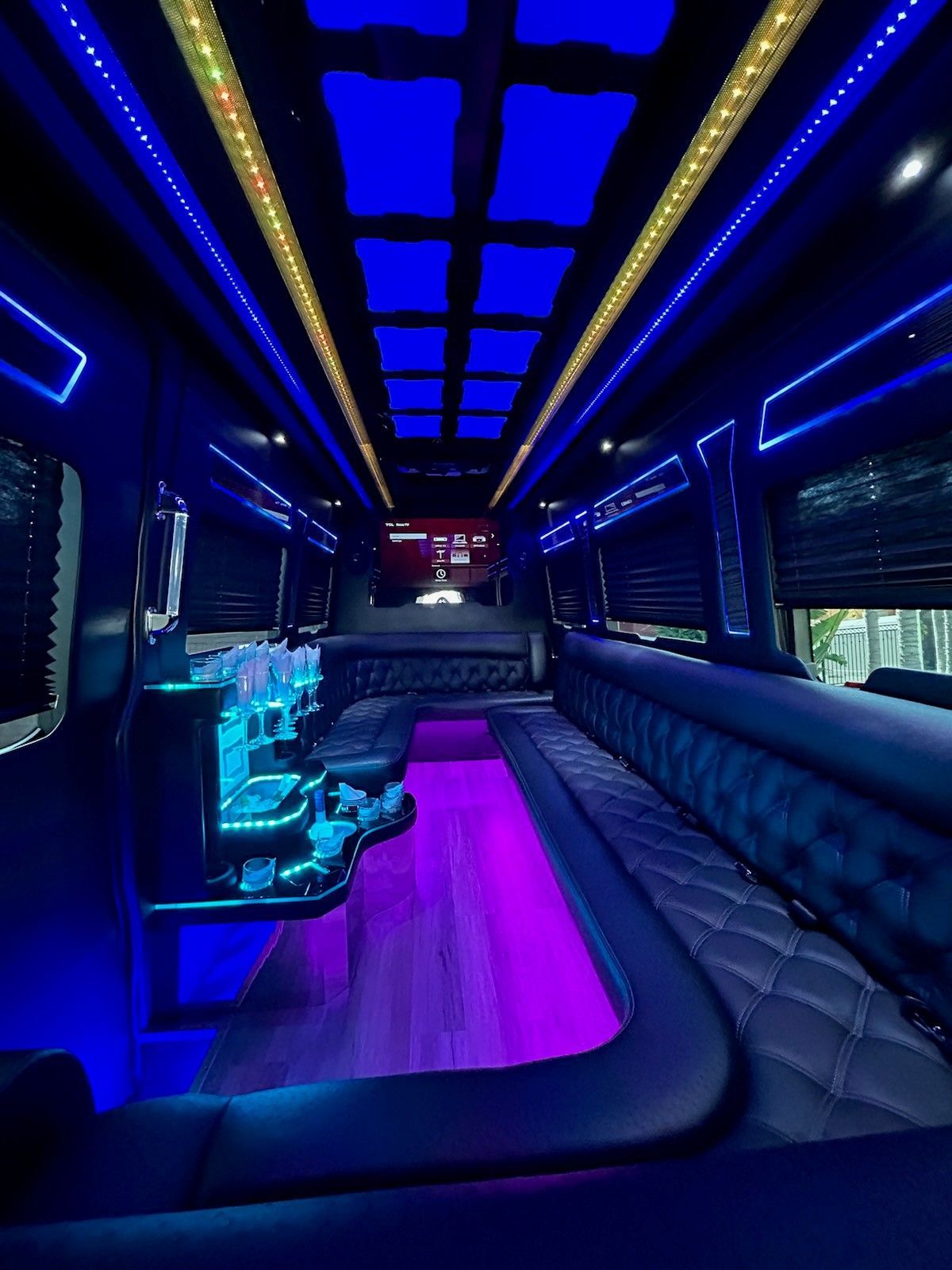 A black chair is sitting in a room with purple lights.
