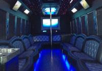 The inside of a limousine with blue lights and a pole.