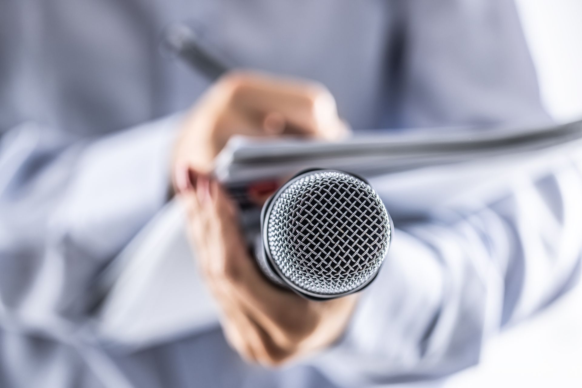 A person is holding a microphone in their hand.